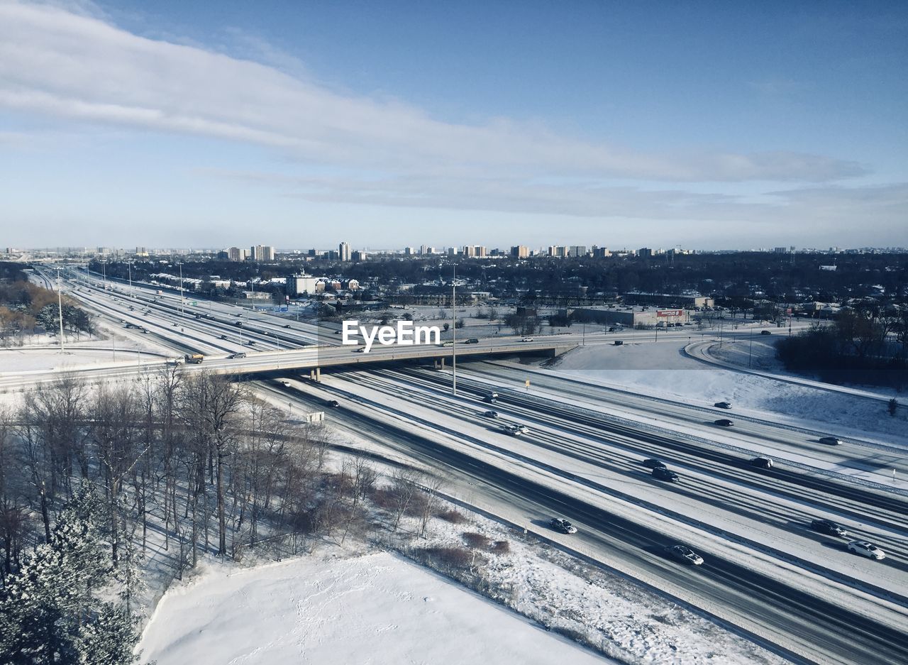 HIGH ANGLE VIEW OF CITYSCAPE AGAINST SKY DURING WINTER