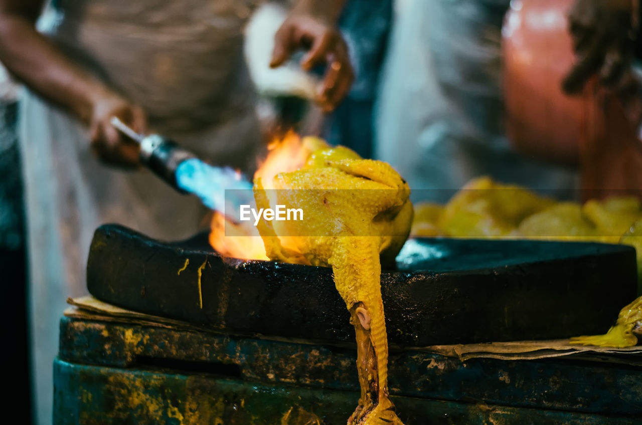 Midsection of chef preparing food in commercial kitchen