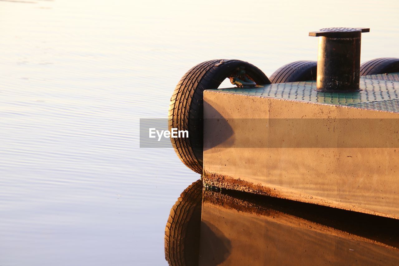 BOAT MOORED BY PIER AGAINST SKY