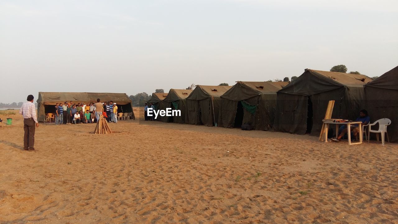 Group of friends camping against clear sky