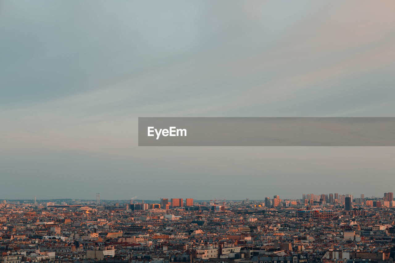 HIGH ANGLE SHOT OF TOWNSCAPE AGAINST SKY AT DUSK