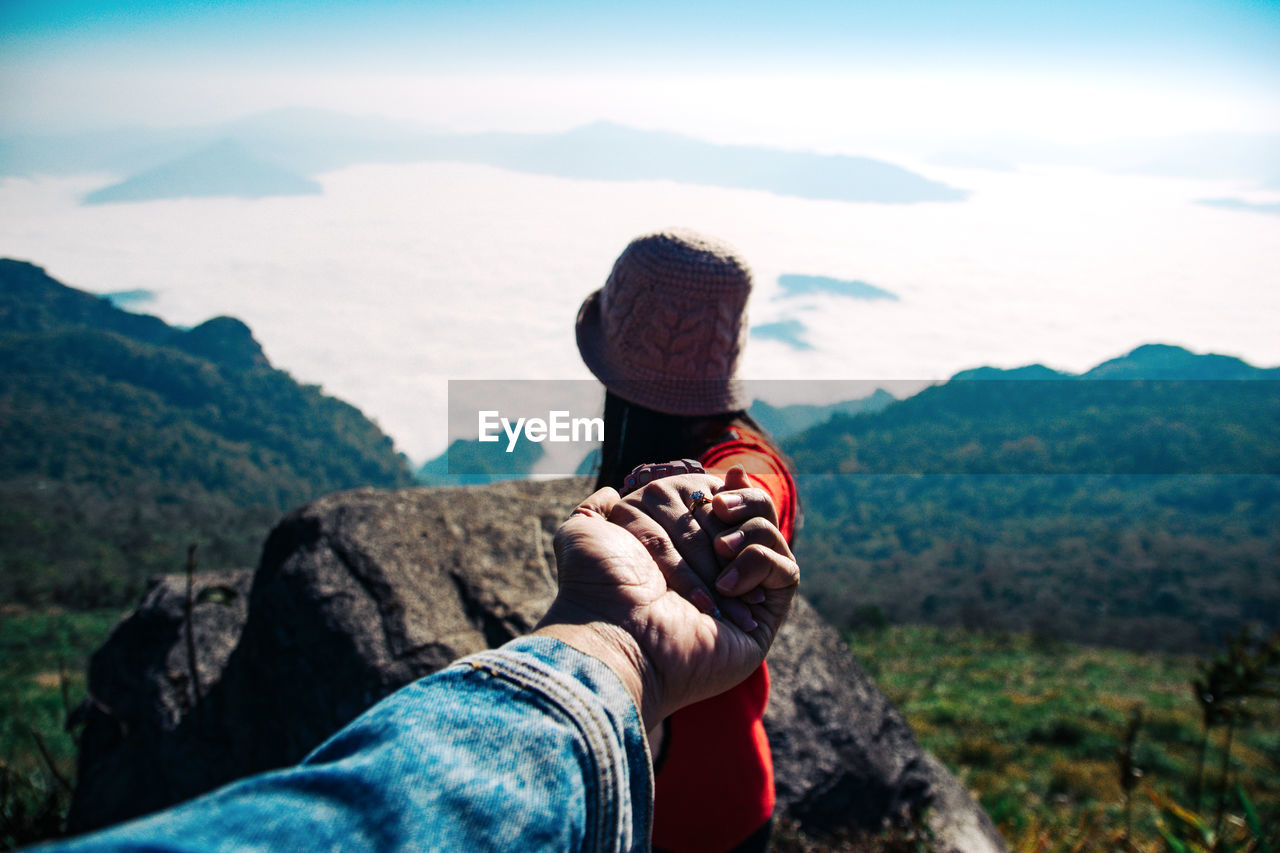 Woman holding hand of man on mountain