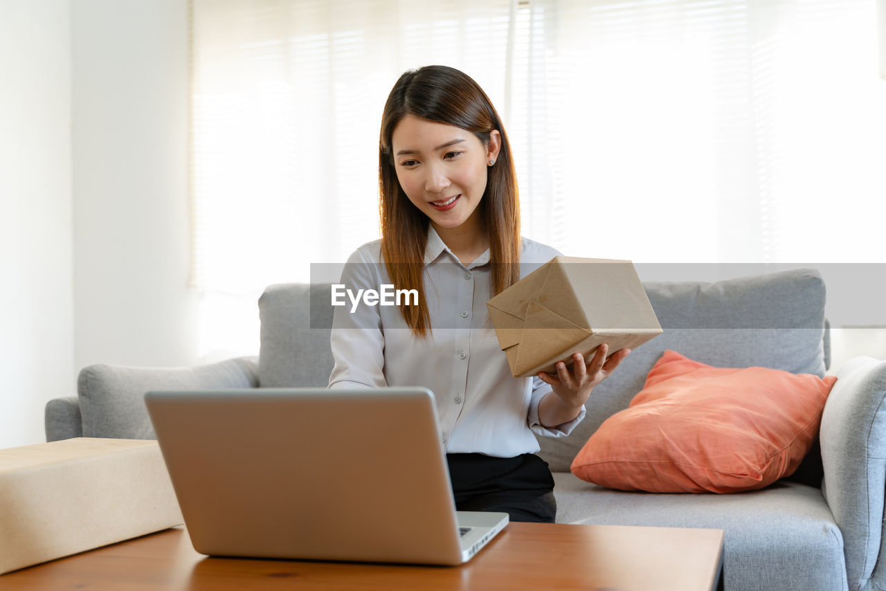 young woman using laptop while sitting at home