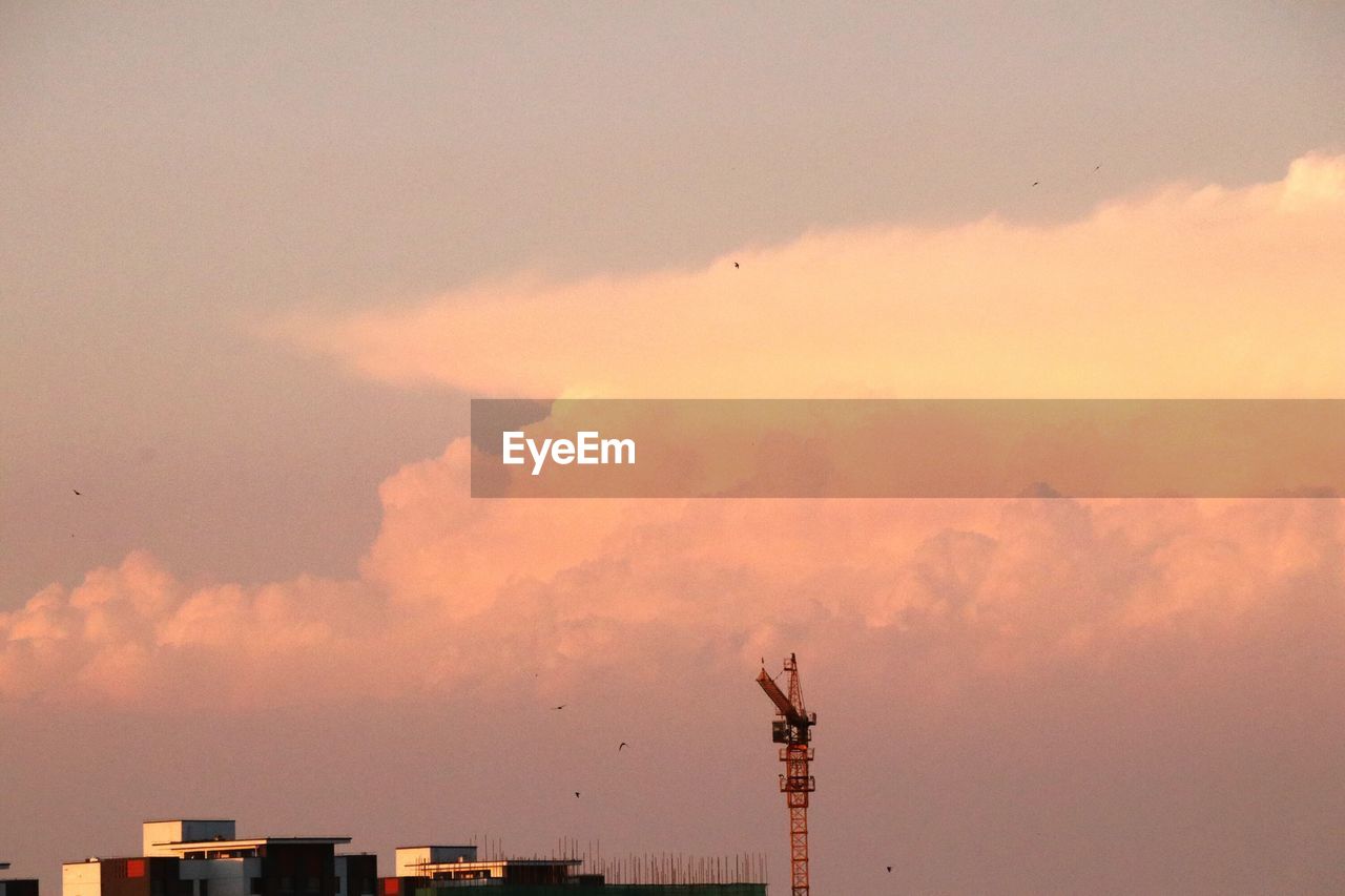 HIGH SECTION OF SILHOUETTE BUILDINGS AGAINST SKY DURING SUNSET