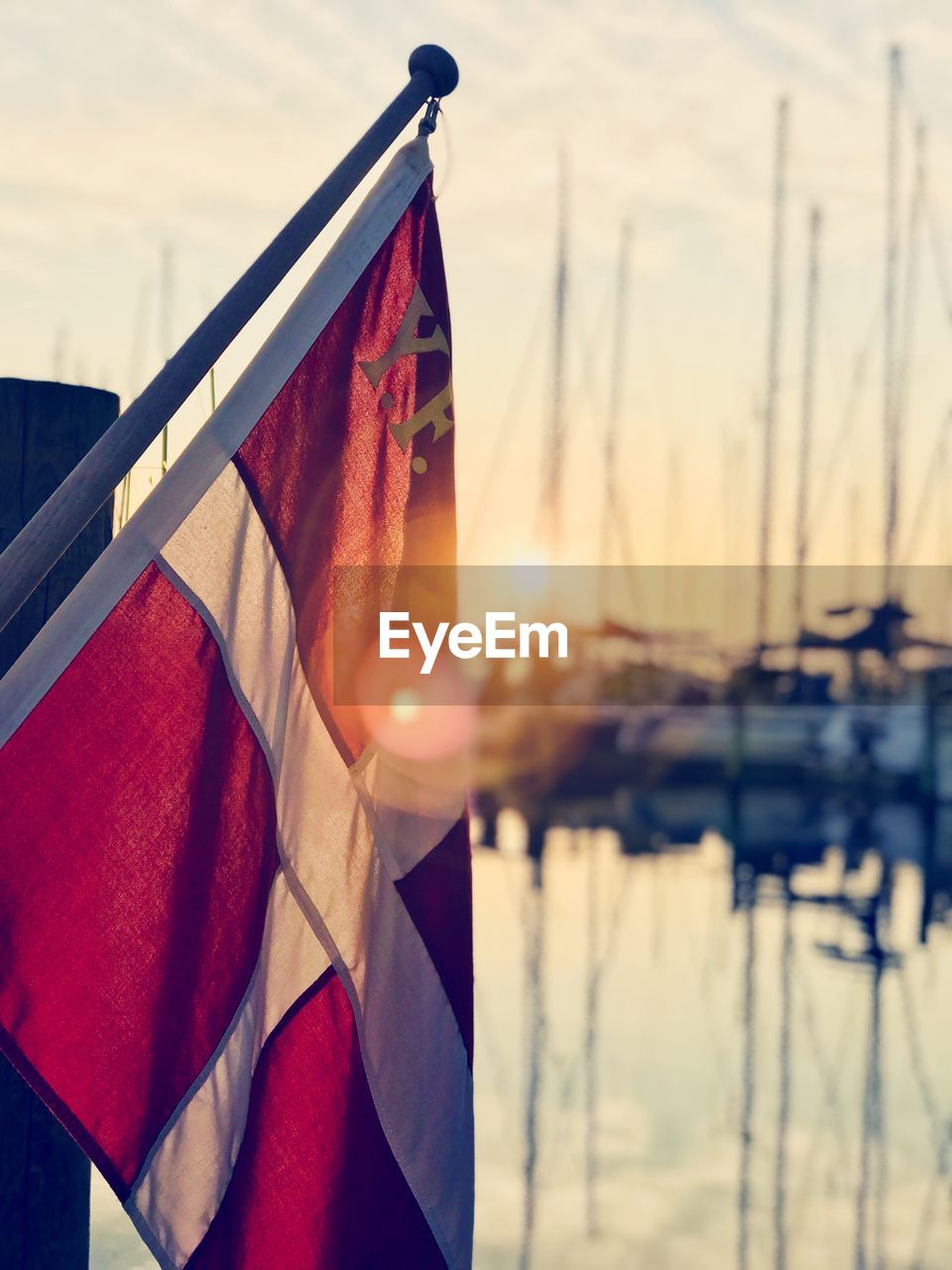 Close-up of danish flag against sky during sunset
