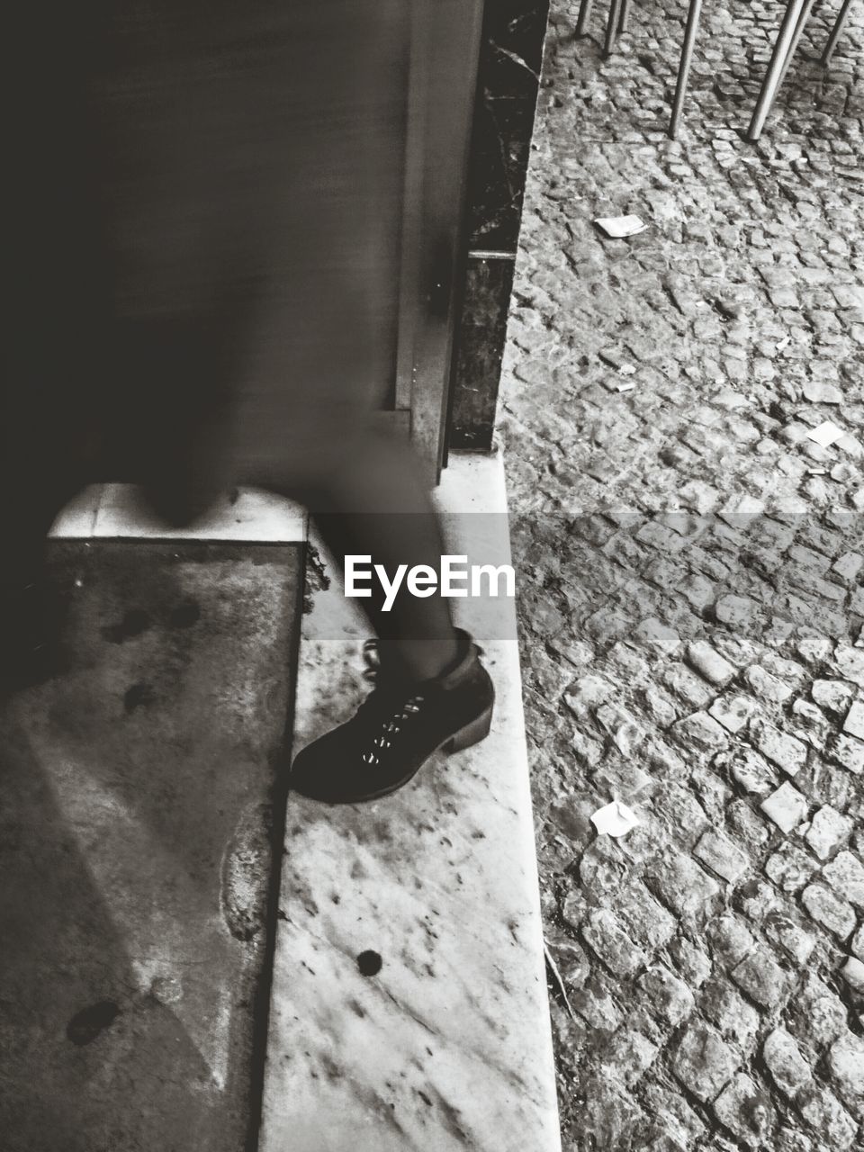 LOW SECTION OF WOMAN STANDING ON COBBLESTONE