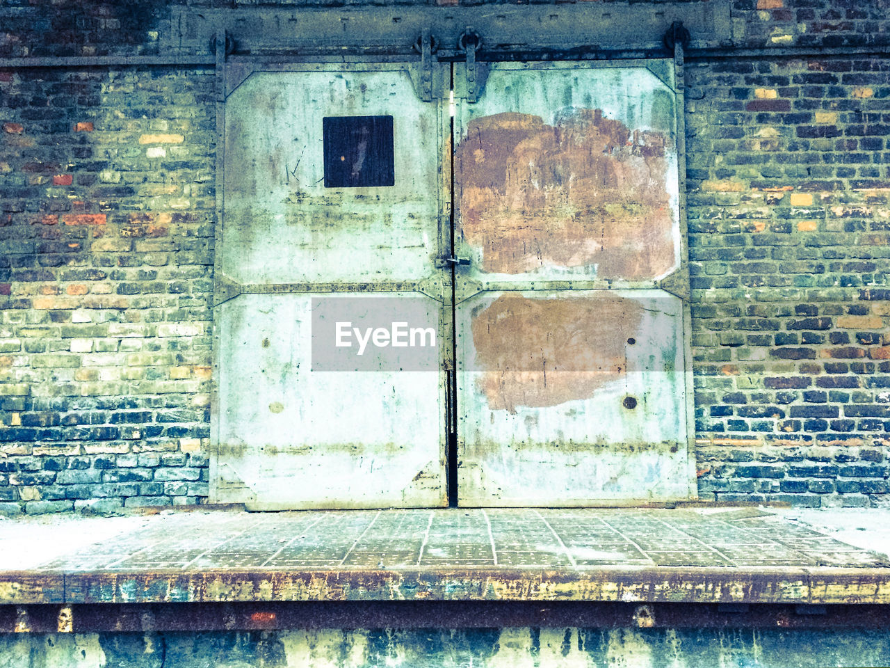 CLOSE-UP OF BRICK WALL WITH BUILDING