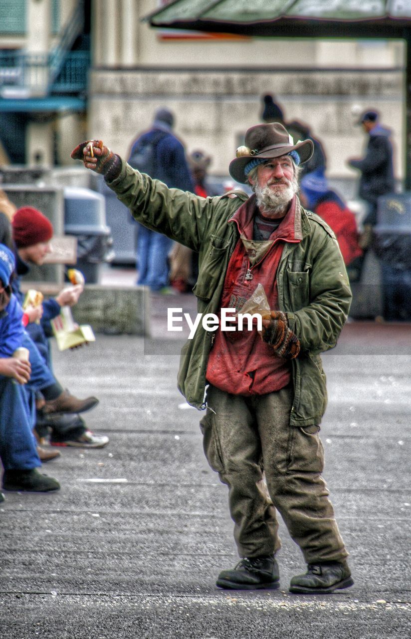 MEN STANDING ON STREET IN CITY