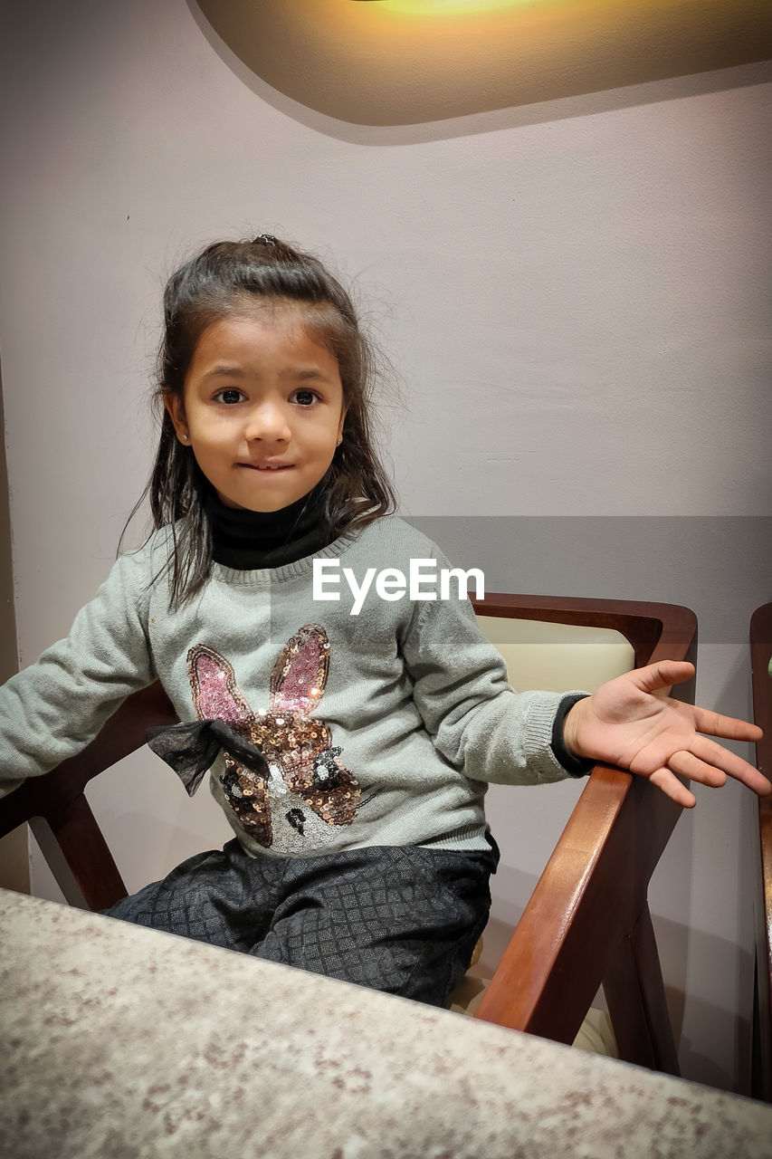 Portrait of smiling girl sitting at home