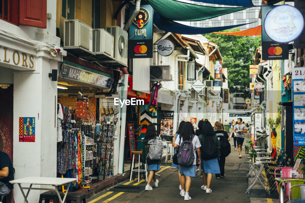 Rear view of people walking on street in singapore 