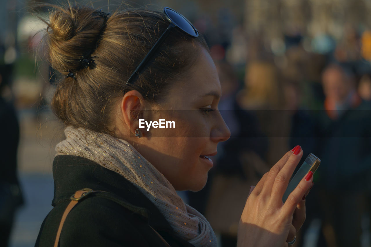 Close-up of woman using mobile phone outdoors