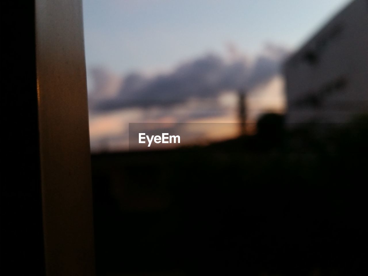 CLOSE-UP OF WINDOW AGAINST SKY AT SUNSET