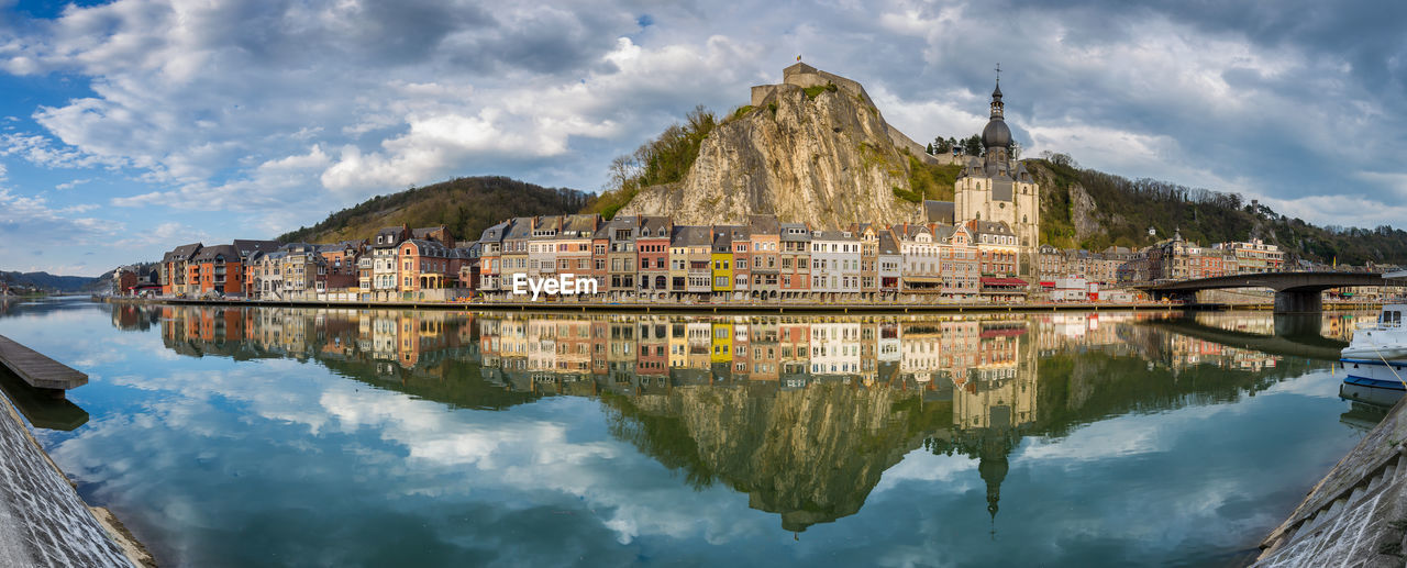 Scenic view of lake by buildings against sky