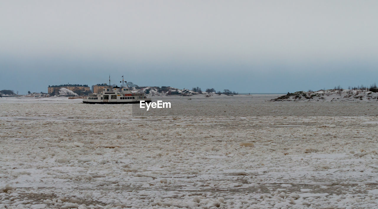 SHIP ON BEACH AGAINST SKY