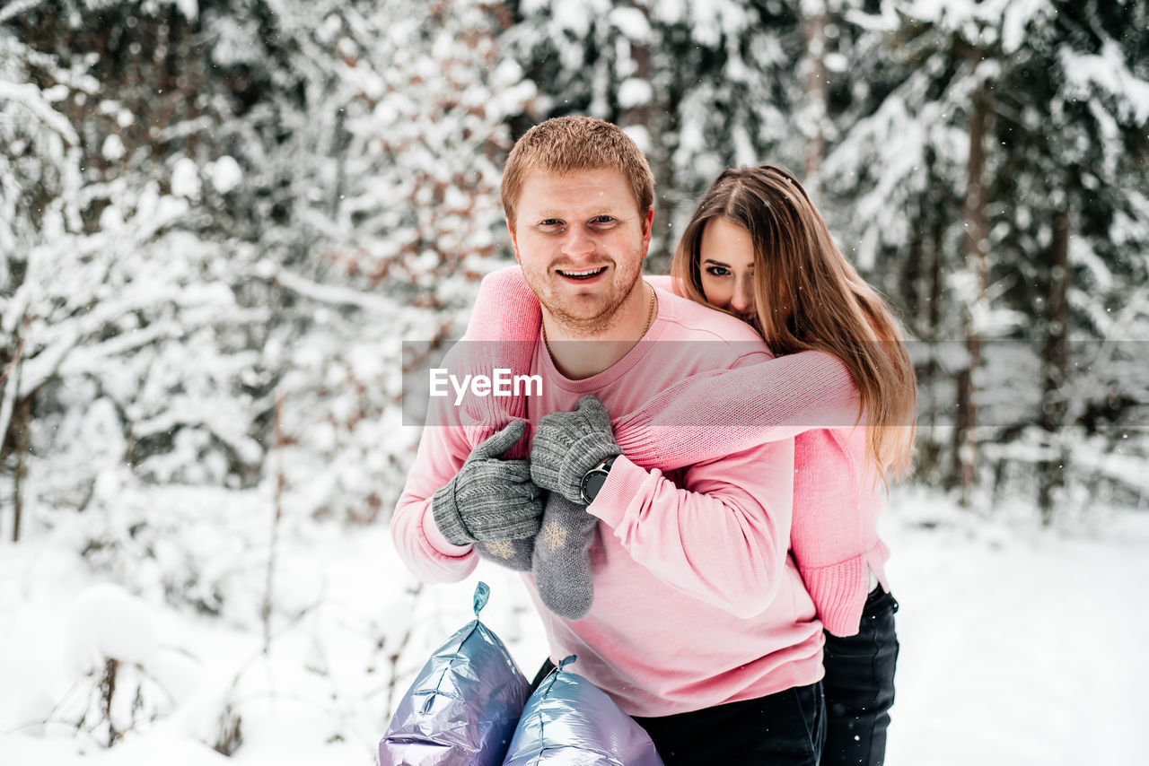 Portrait of couple embracing while standing outdoors during winter