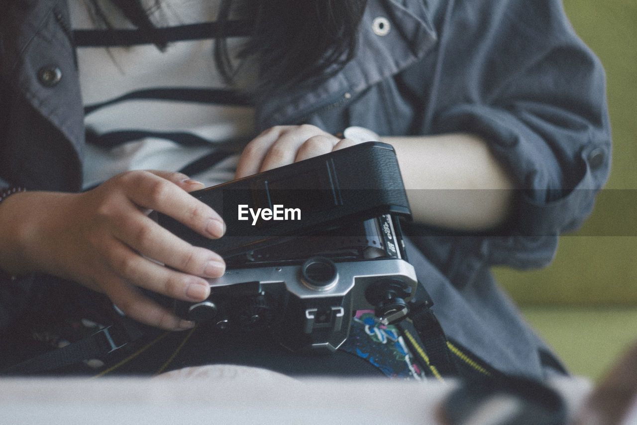 Midsection of woman holding camera