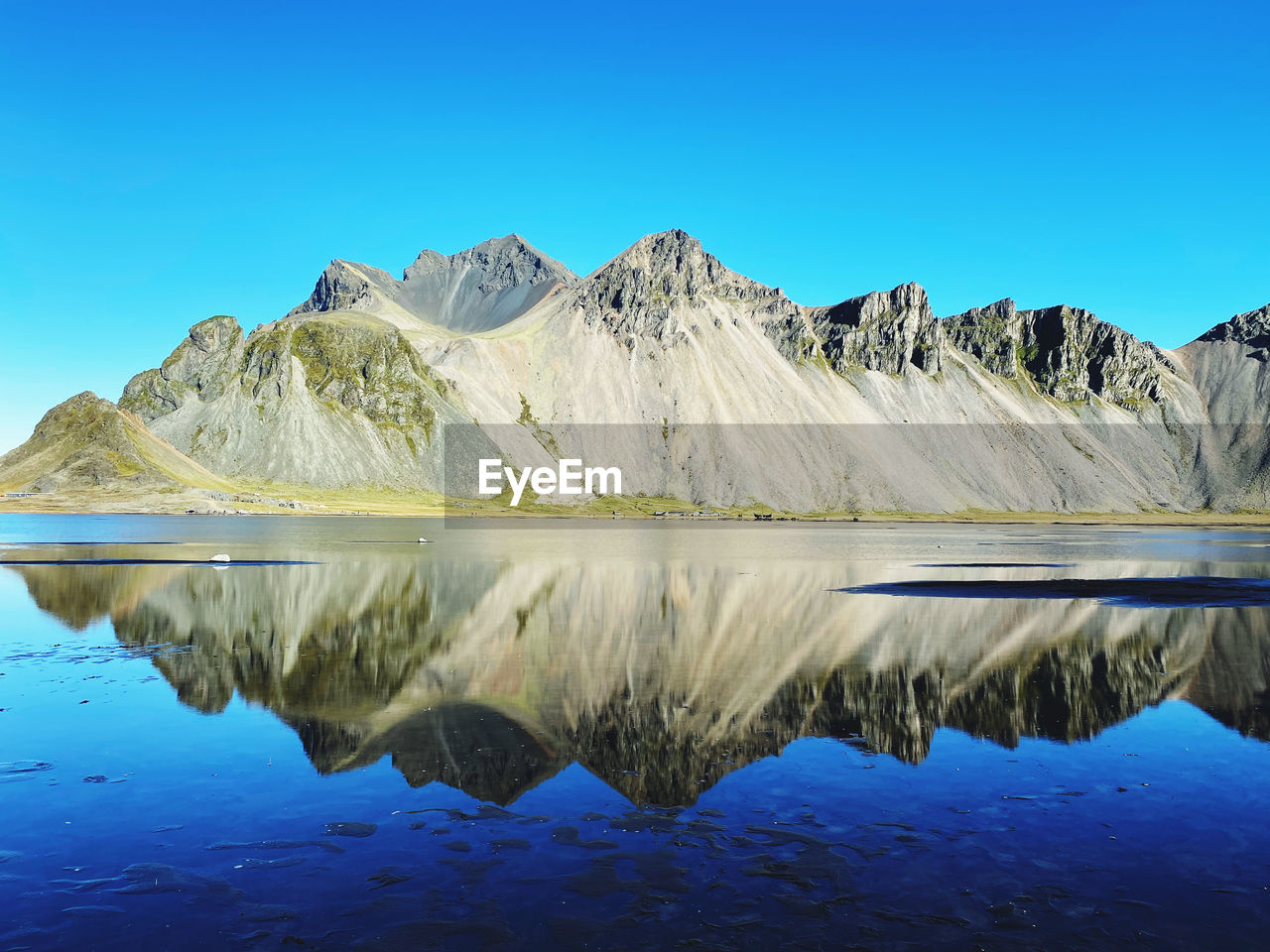 water, reflection, mountain, lake, scenics - nature, sky, blue, beauty in nature, nature, landscape, mountain range, environment, wilderness, tranquility, tranquil scene, clear sky, no people, travel destinations, travel, cold temperature, land, horizon, non-urban scene, outdoors, day, snow, lagoon, idyllic, copy space