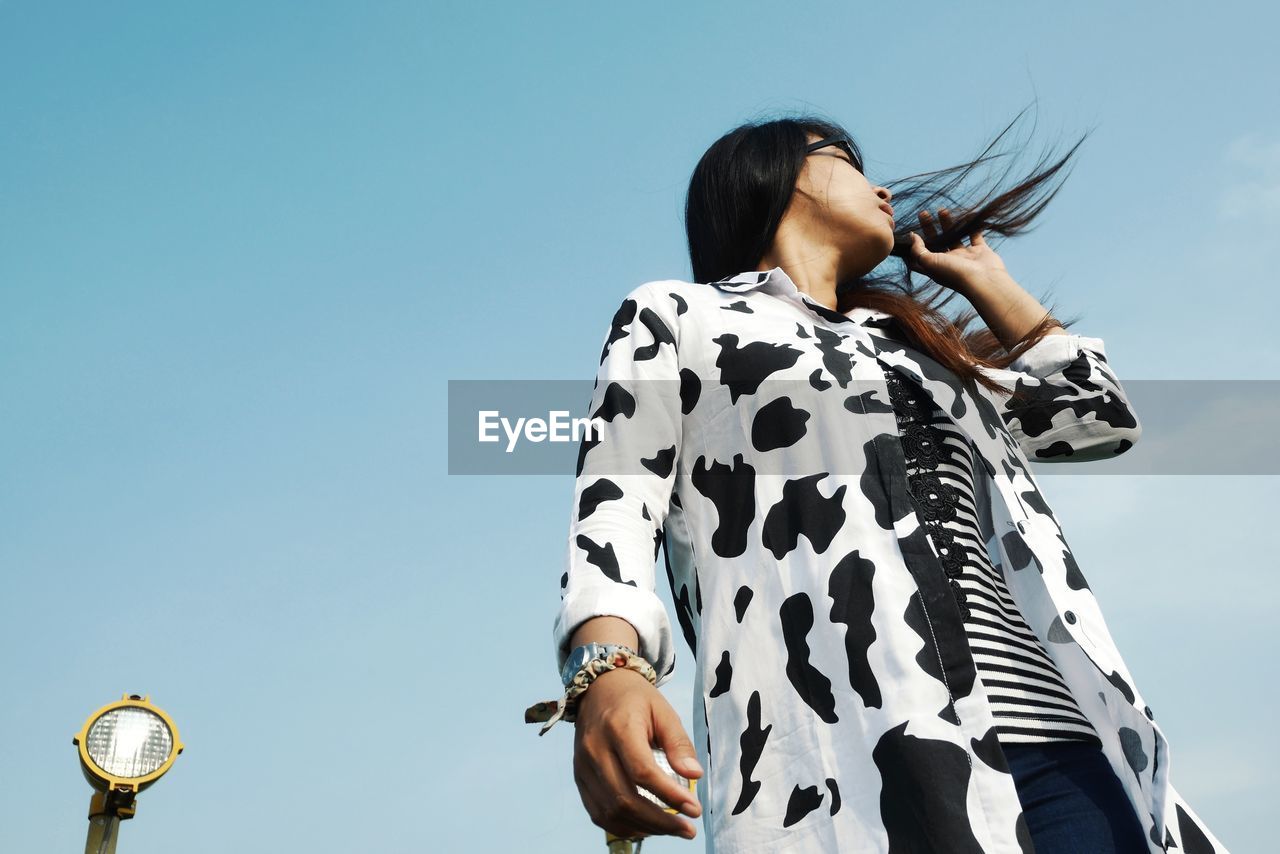 A girl tossing her hair in the middle of a sunny day