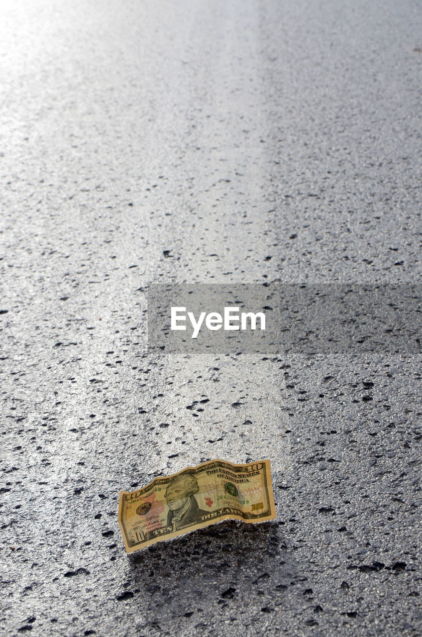 High angle view of paper currency fallen on road