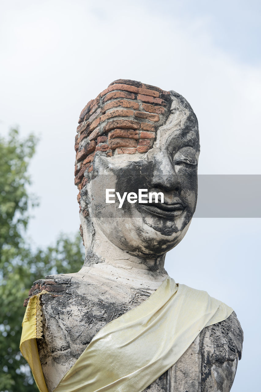 Low angle view of old damaged buddha statue and temple