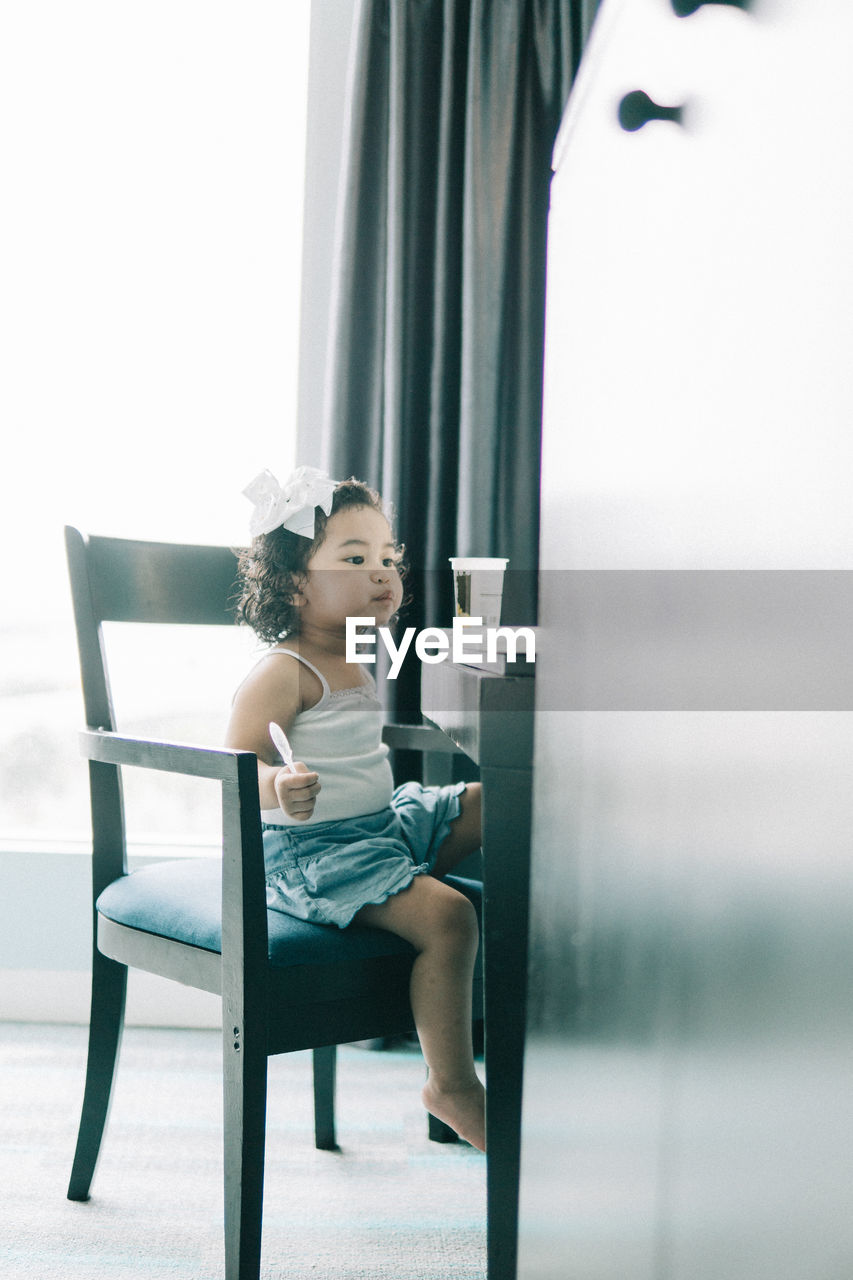 Girl sitting on table at home