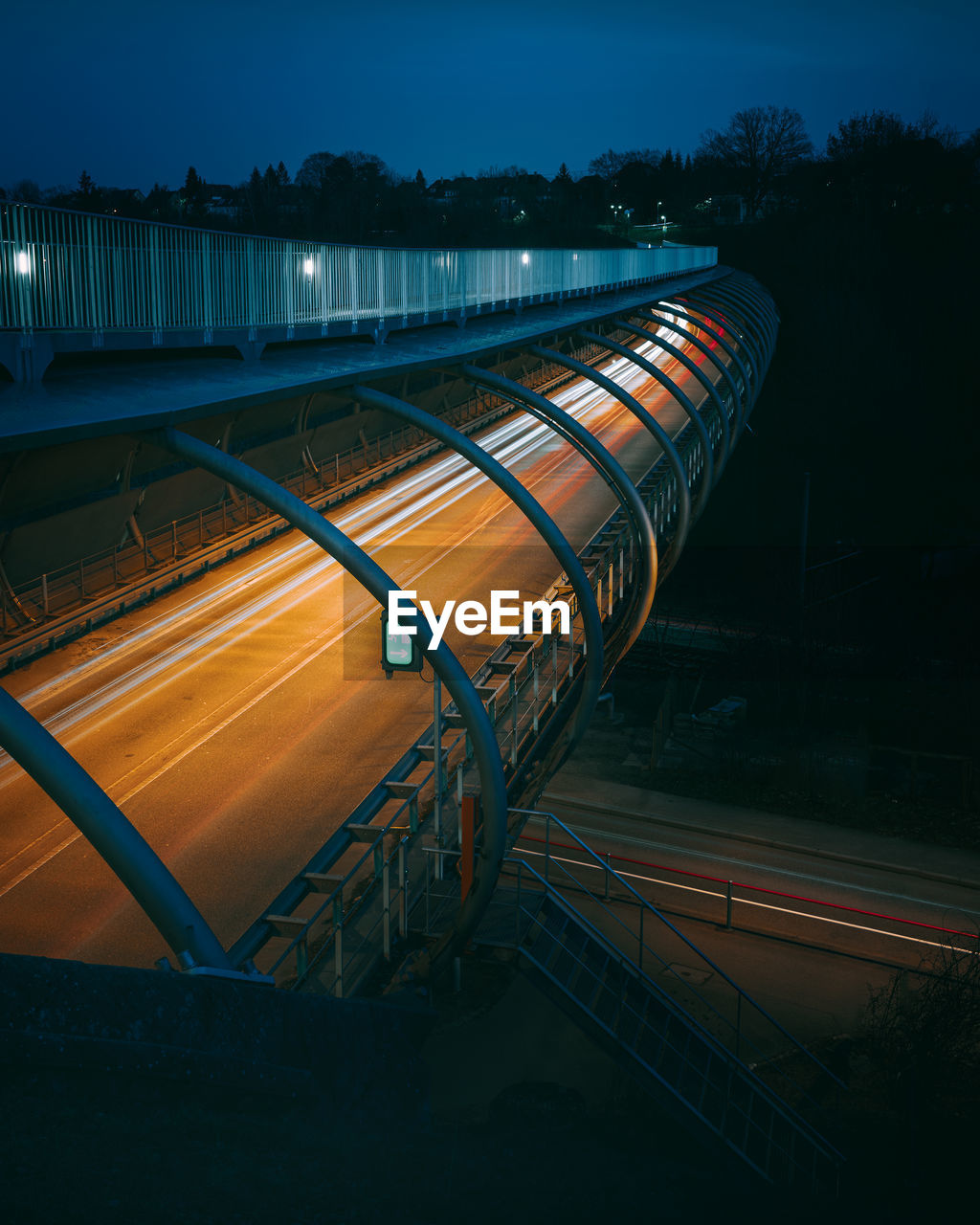 Light trails of cars driving an s-shaped modern steel bridge