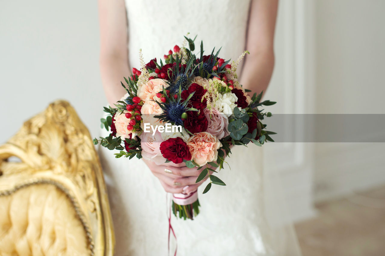 Midsection of woman holding bouquet