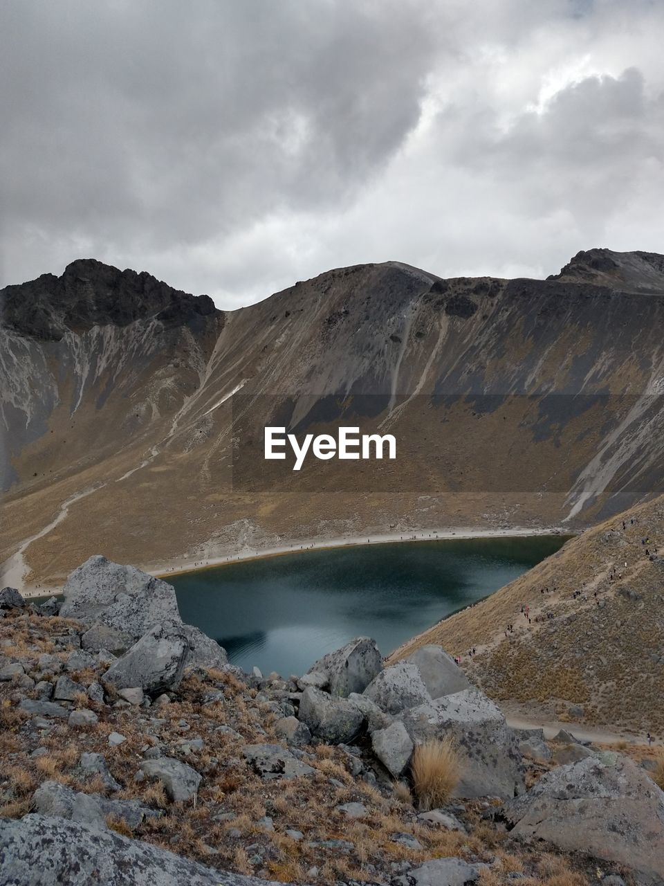 Scenic view of lake by mountains against sky