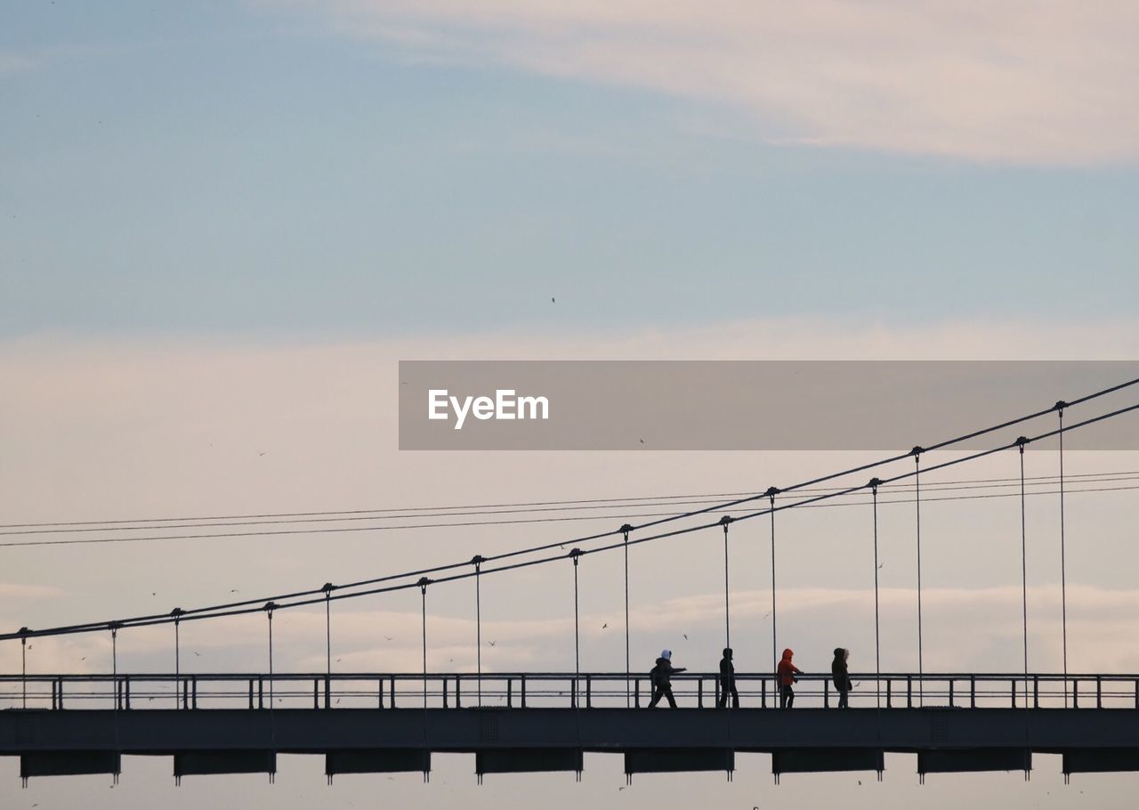 People on bridge against sky