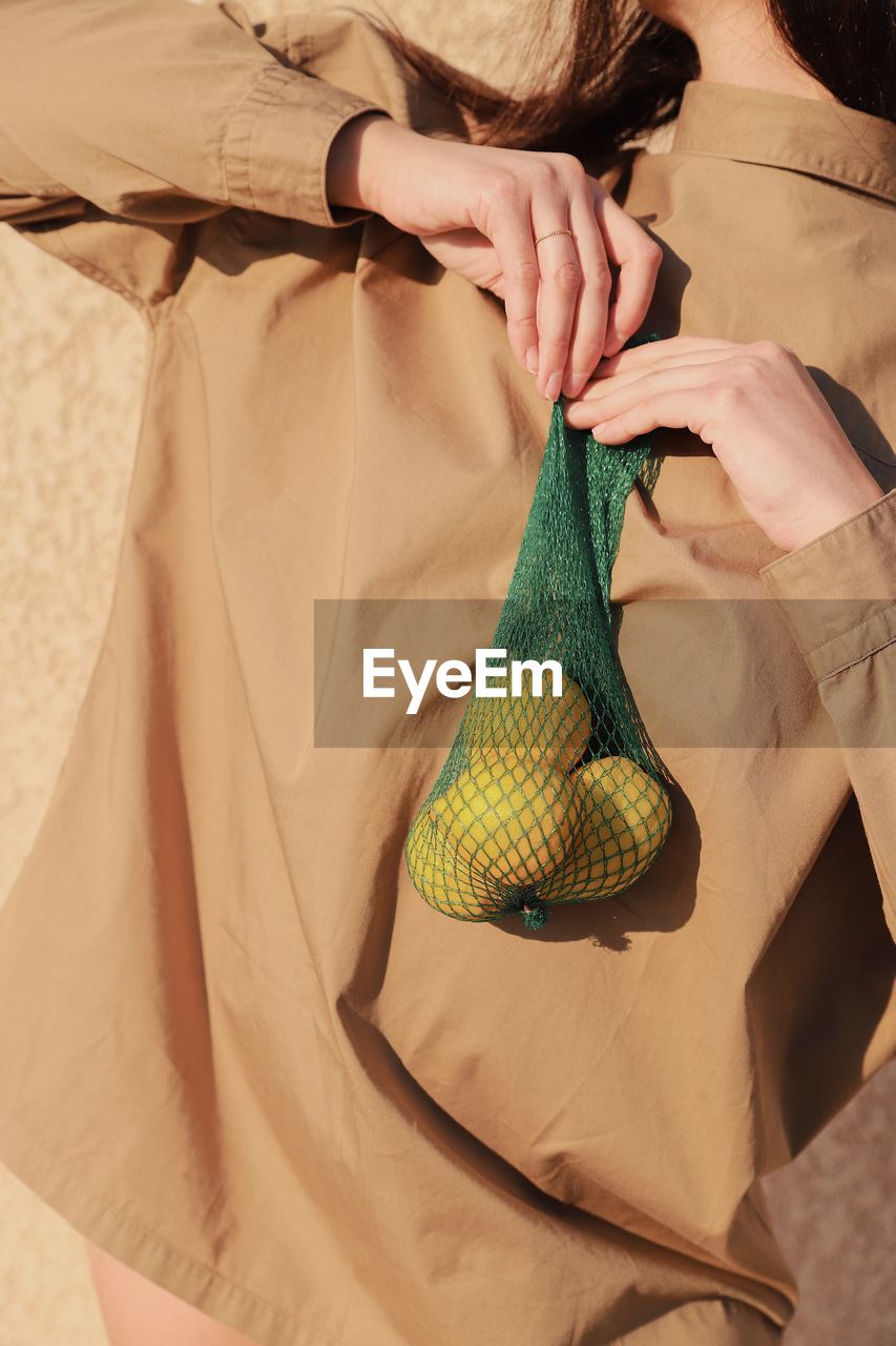 Midsection of woman holding fruits