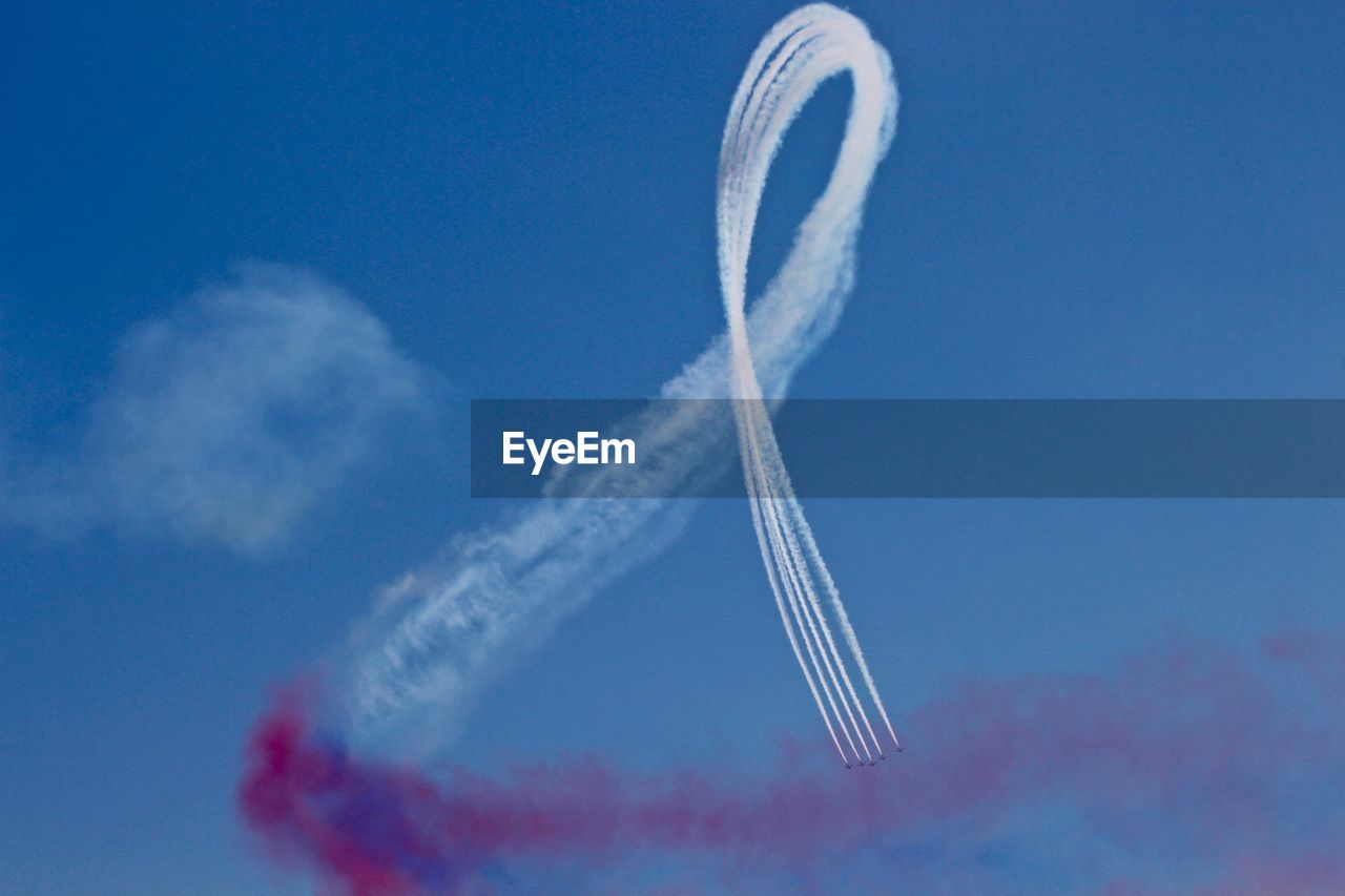 LOW ANGLE VIEW OF VAPOR TRAILS IN SKY