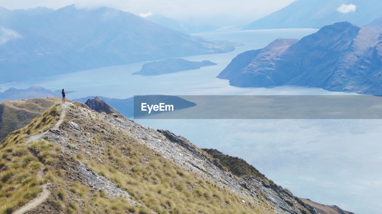 Person standing on mountain by river