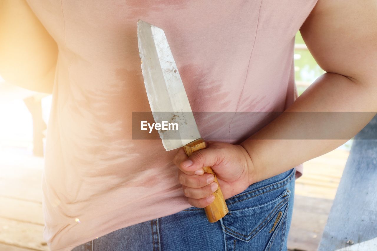 MIDSECTION OF WOMAN HOLDING FOOD