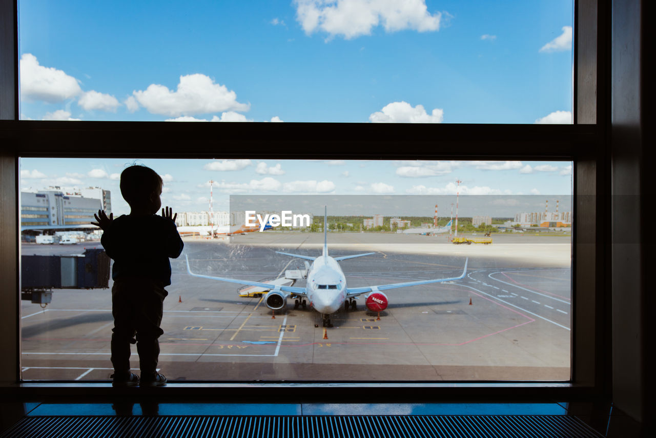 rear view of man standing on airport