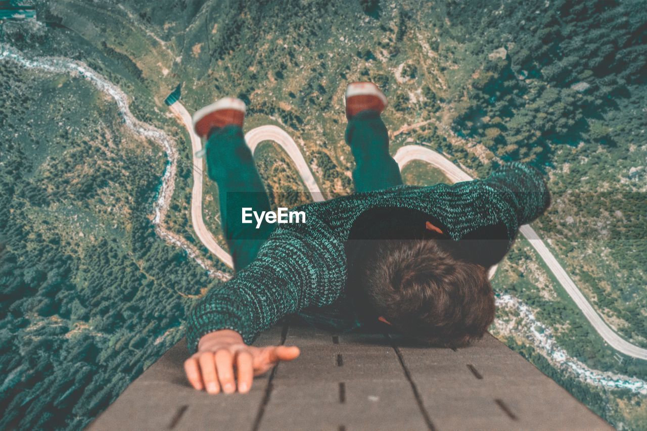 High angle view of boy hanging over landscape