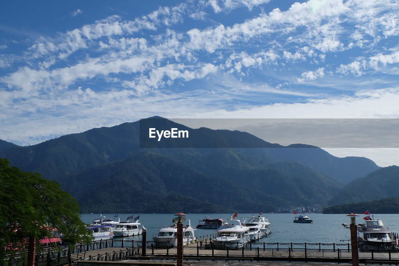 SCENIC VIEW OF BAY AGAINST MOUNTAINS