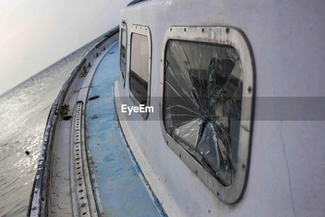 Close-up of broken window in sailboat on sea