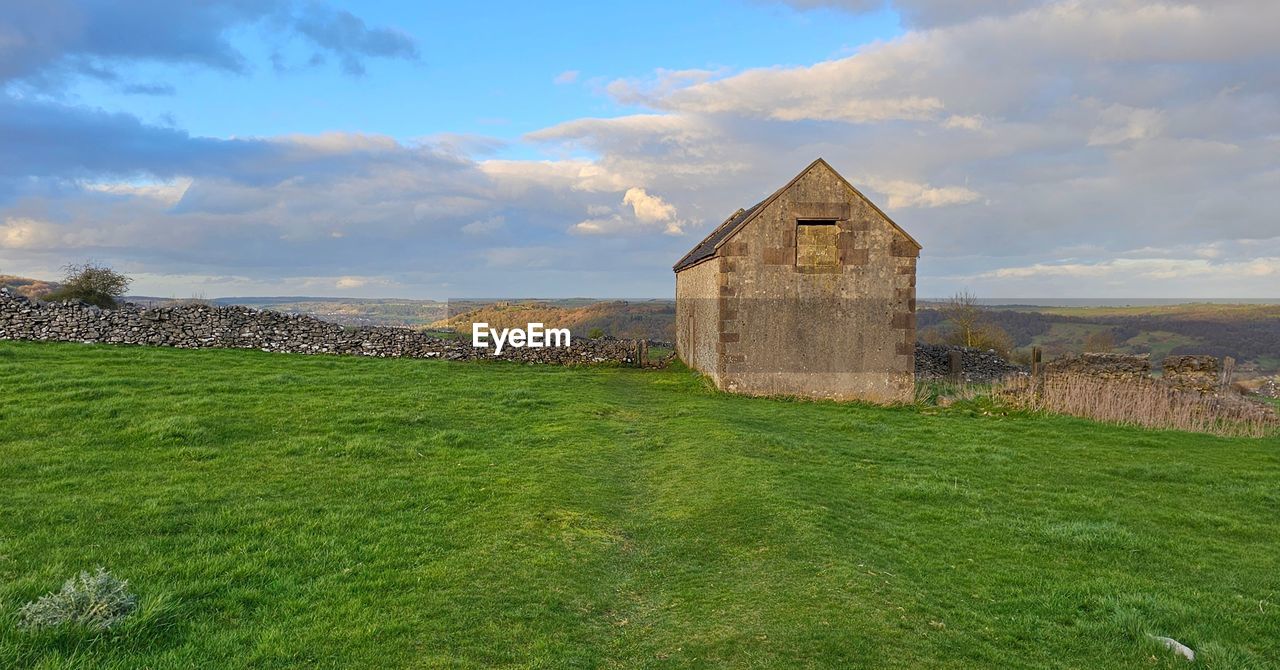 architecture, sky, built structure, rural area, cloud, hill, landscape, grass, building, building exterior, plant, nature, land, history, rural scene, environment, the past, field, scenics - nature, green, highland, no people, prairie, meadow, house, travel destinations, beauty in nature, pasture, place of worship, religion, old, ruins, abandoned, non-urban scene, outdoors, travel, farm, tranquility, agricultural building, old ruin, grassland, agriculture, residential district, rock, stone material, tranquil scene, plain, tourism, horizon, ancient, day