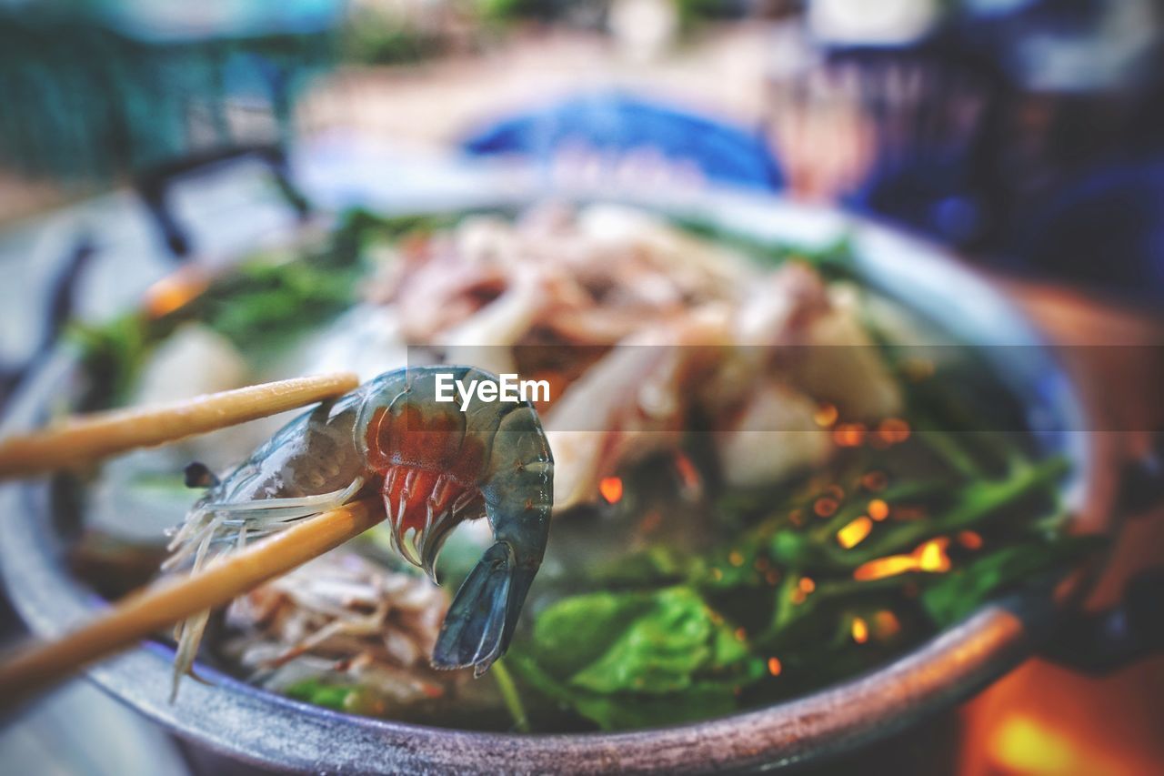 Close-up of chopsticks holding seafood