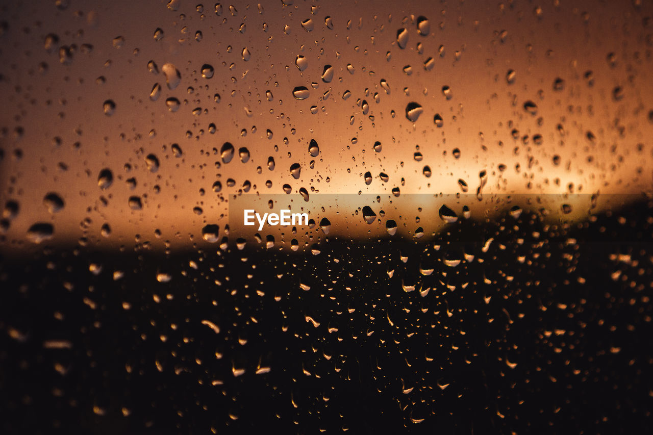 FULL FRAME SHOT OF RAINDROPS ON GLASS WINDOW