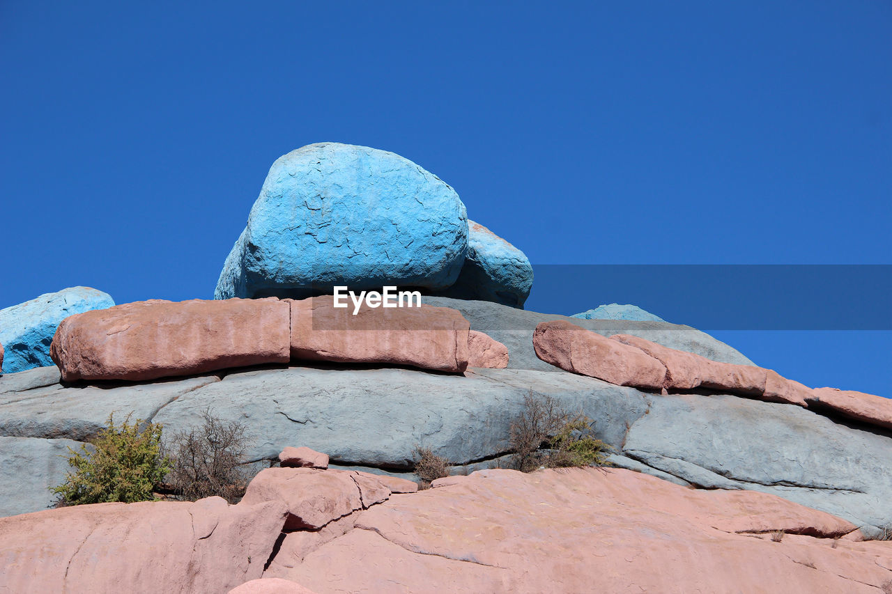 LOW ANGLE VIEW OF ROCK AGAINST CLEAR BLUE SKY