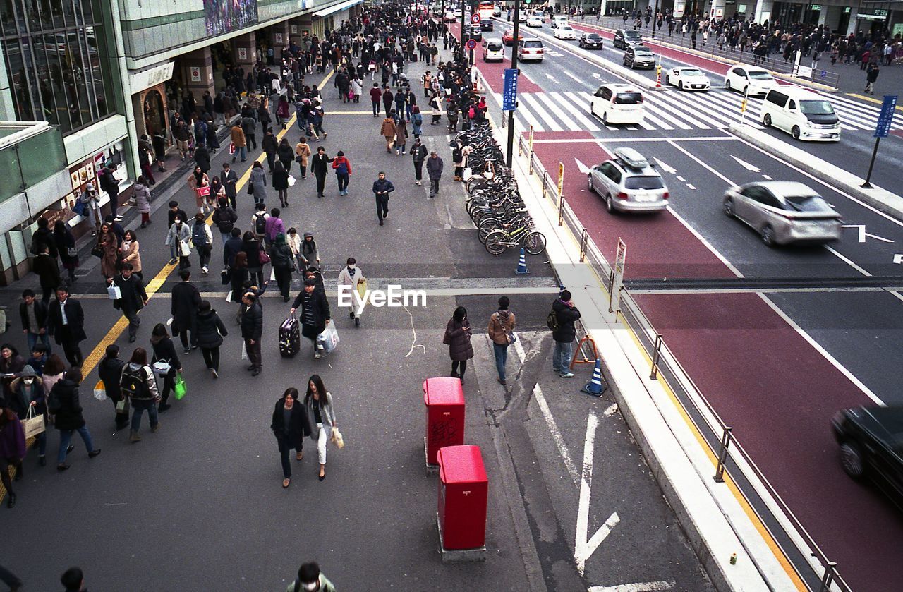 HIGH ANGLE VIEW OF PEOPLE ON CITY STREET