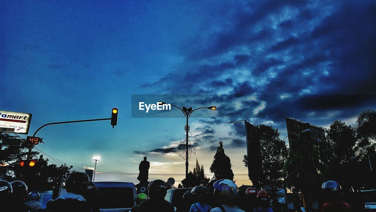 LOW ANGLE VIEW OF ILLUMINATED STREET LIGHT AGAINST CLOUDY SKY