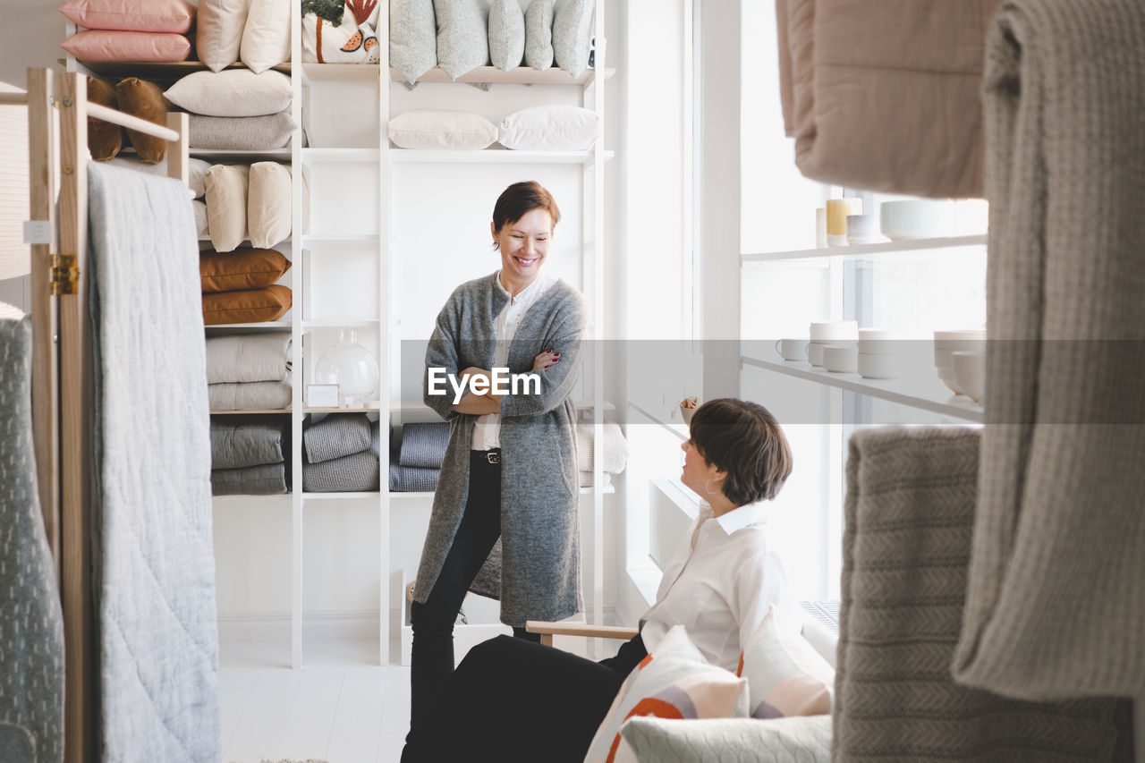 Smiling female designer talking with colleague in store