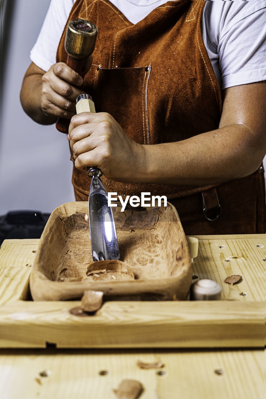 Craftswoman working with wooden tray