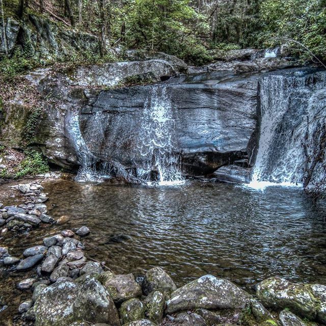 SCENIC VIEW OF RIVER FLOWING THROUGH ROCKS IN FOREST