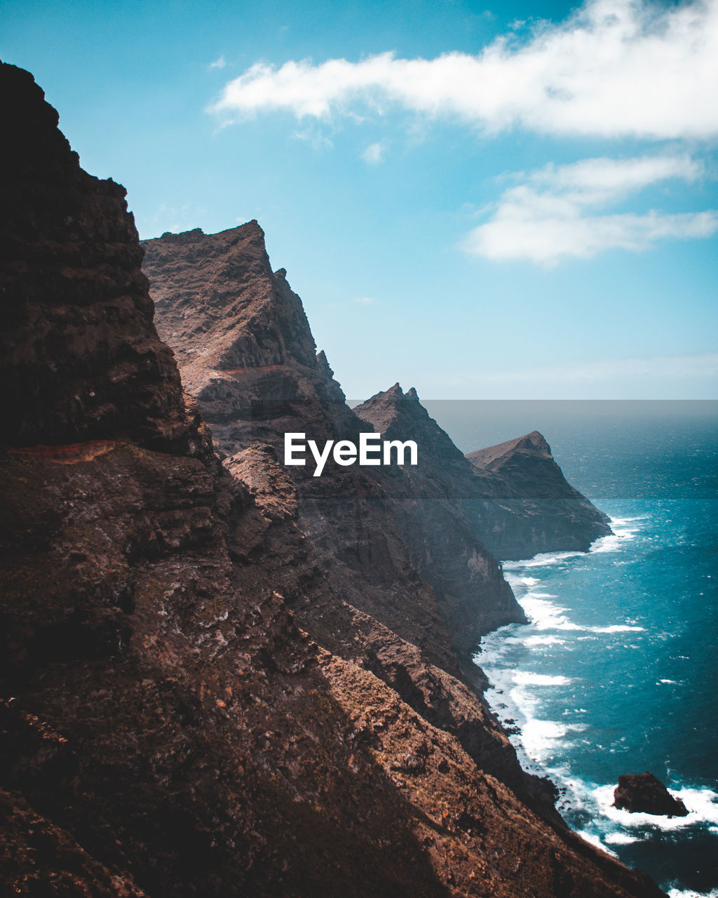 Rock formations by sea against sky