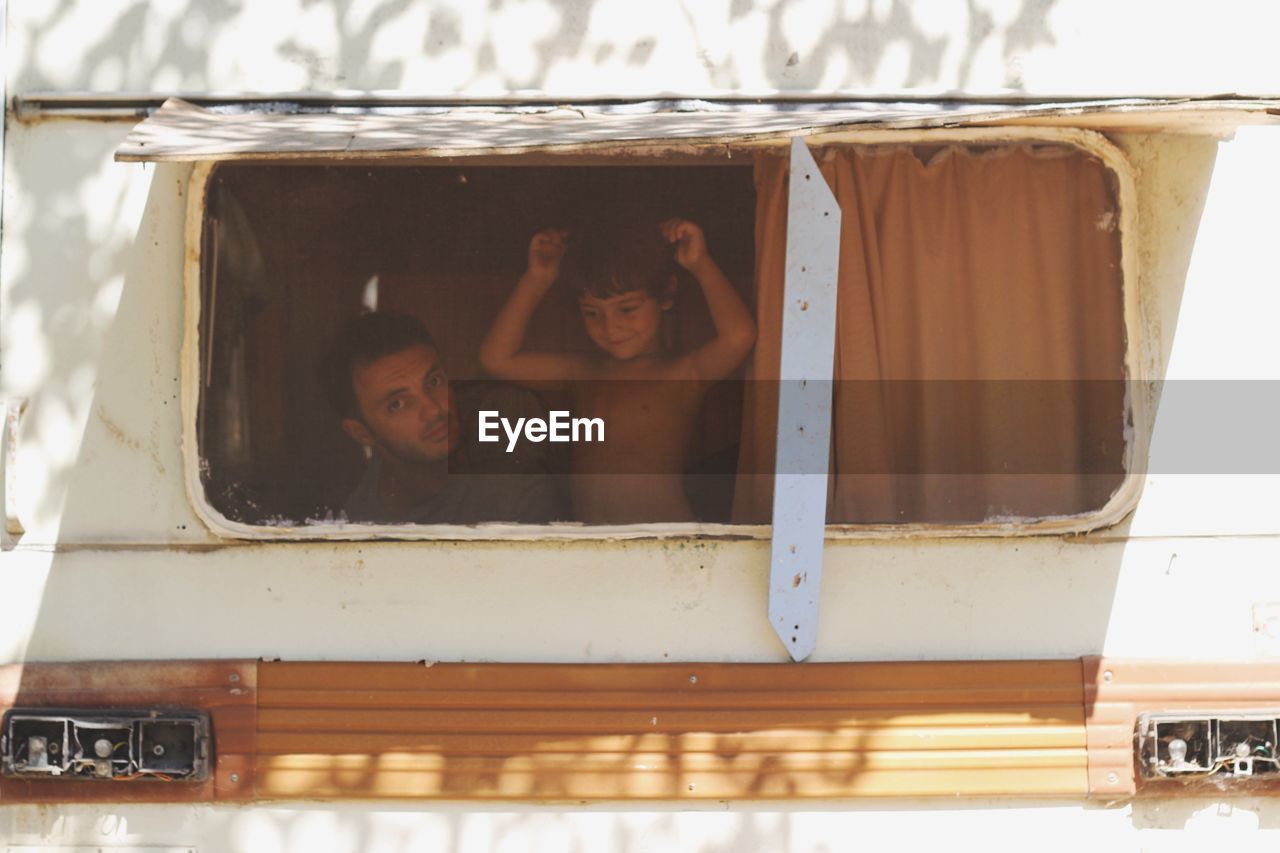 Portrait of father with son seen through motor home window