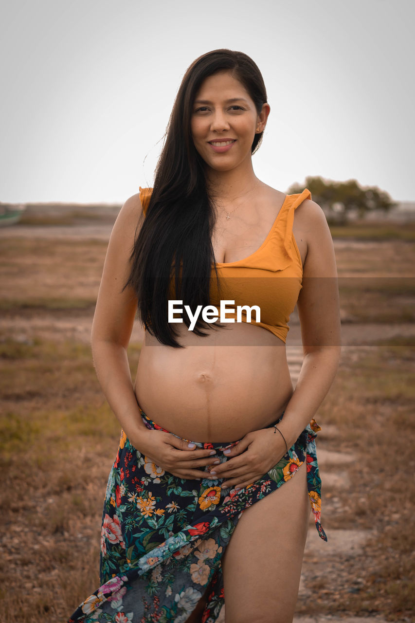 Portrait of young woman standing at beach