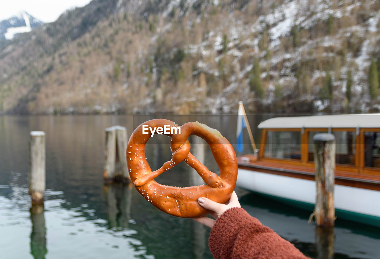 Woman holding a pretzel.